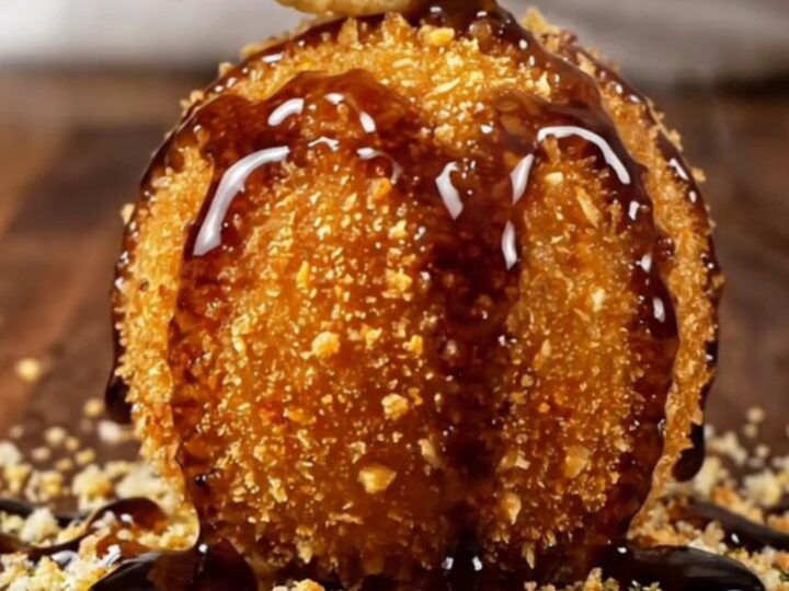 A golden-brown croquette broken open to show a creamy blue cheese and walnut center.