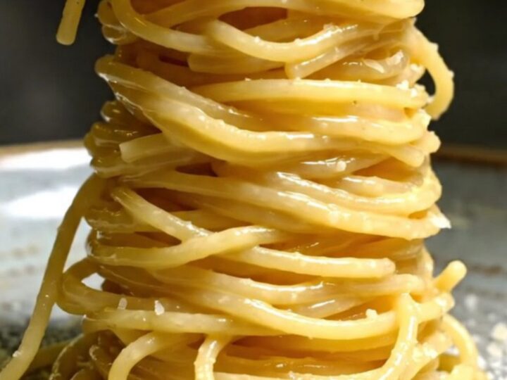 A towering nest of glossy spaghetti alla chitarra coated in a creamy egg and Pecorino sauce, topped with crispy guanciale.
