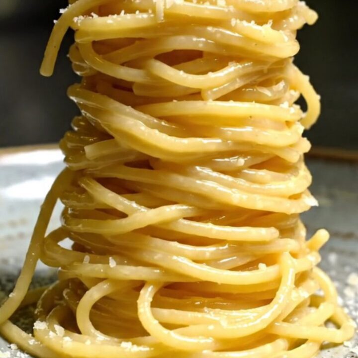 A towering nest of glossy spaghetti alla chitarra coated in a creamy egg and Pecorino sauce, topped with crispy guanciale.