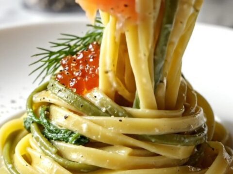 A close-up of smoked salmon fettuccine in a lemon cream sauce topped with salmon roe and fresh dill.