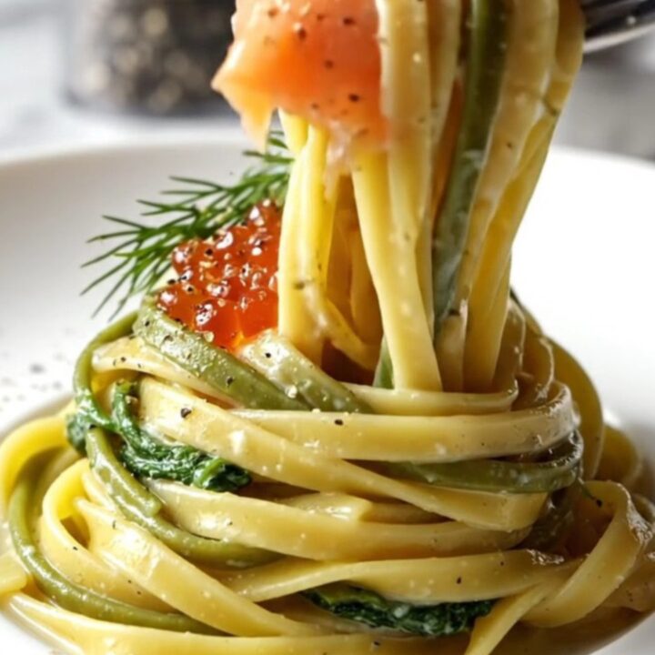 A close-up of smoked salmon fettuccine in a lemon cream sauce topped with salmon roe and fresh dill.