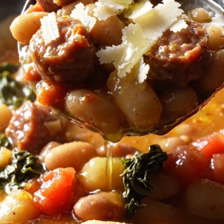 A rustic cast-iron skillet filled with browned Italian sausage, gnocchi, white beans, and kale in a creamy tomato sauce.
