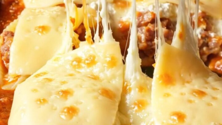 A close-up of jumbo pasta shells stuffed with spicy sausage and ricotta, baked until golden in a garlic marinara sauce.