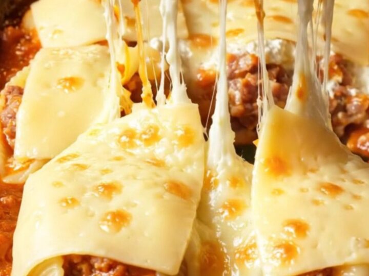 A close-up of jumbo pasta shells stuffed with spicy sausage and ricotta, baked until golden in a garlic marinara sauce.