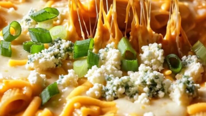 A close-up of a bubbling, cheesy buffalo chicken ranch baked penne with a crispy golden top.