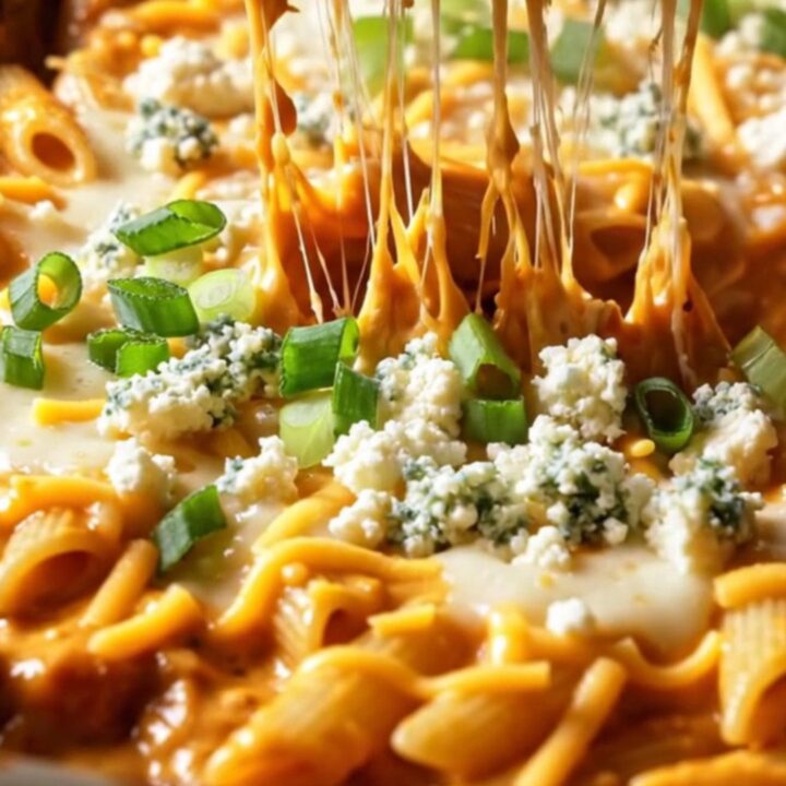 A close-up of a bubbling, cheesy buffalo chicken ranch baked penne with a crispy golden top.