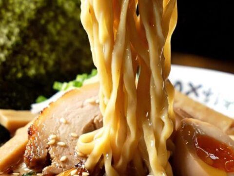 A steaming bowl of tonkotsu ramen with a swirl of black garlic oil and torched chashu pork belly.