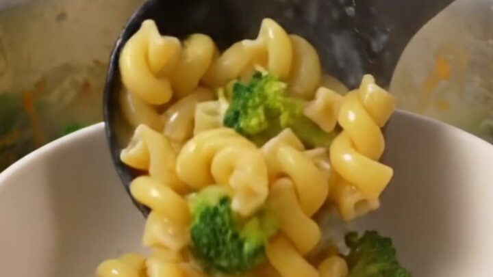 A large pot filled with creamy broccoli cheddar cavatappi, showcasing the vibrant green broccoli and smooth cheese sauce.