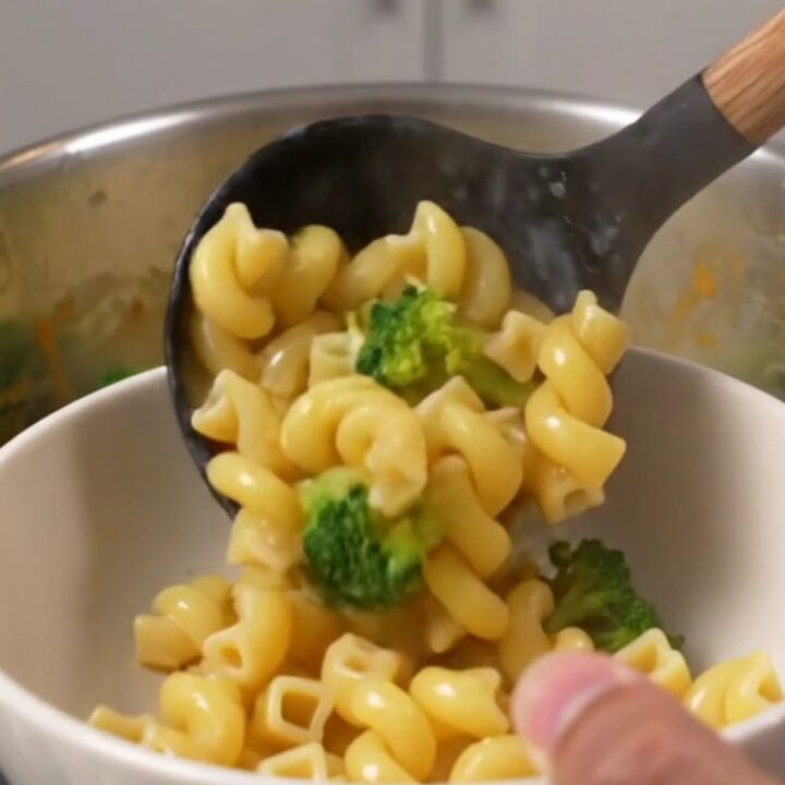 A large pot filled with creamy broccoli cheddar cavatappi, showcasing the vibrant green broccoli and smooth cheese sauce.