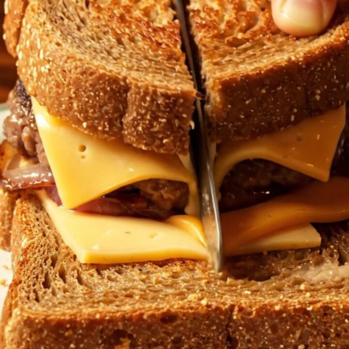 Golden-brown marble rye patty melt with stretching cheese pull and caramelized onions.
