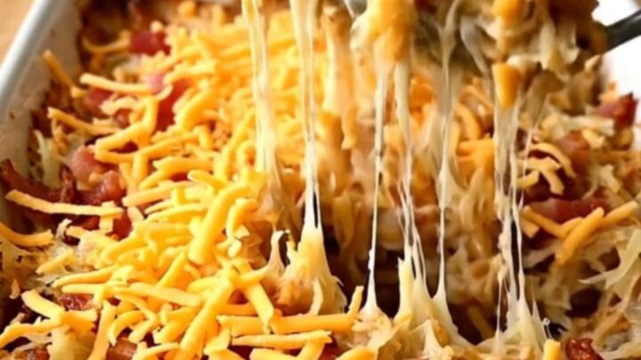 A top-down view of a creamy bacon ranch hash brown casserole in a white baking dish ready for the oven.
