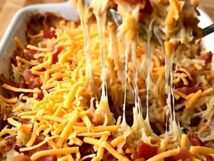 A top-down view of a creamy bacon ranch hash brown casserole in a white baking dish ready for the oven.