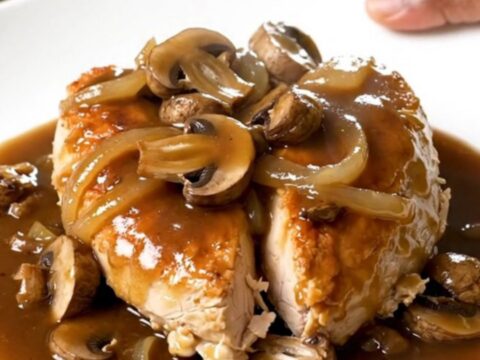 Slow cooker steakhouse mushroom chicken served on a white plate with a rich gravy.