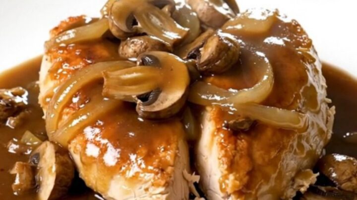 Slow cooker steakhouse mushroom chicken served on a white plate with a rich gravy.