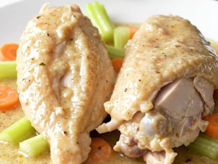 A slow cooker filled with chicken breasts, carrots, celery, and creamy soup before being cooked.