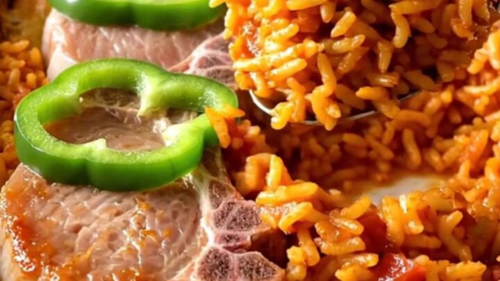 A ceramic baking dish filled with golden pork chops and red tomato rice, ready to be served.