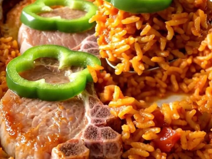 A ceramic baking dish filled with golden pork chops and red tomato rice, ready to be served.