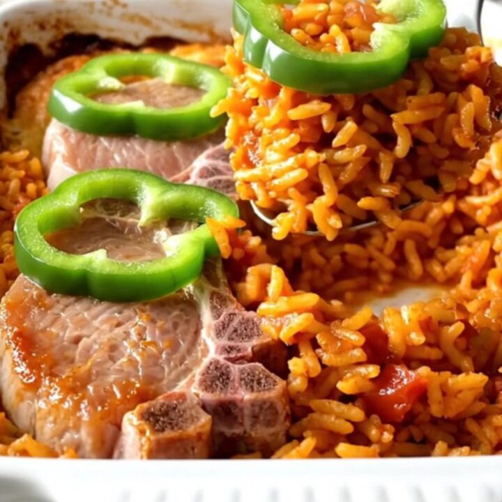 A ceramic baking dish filled with golden pork chops and red tomato rice, ready to be served.