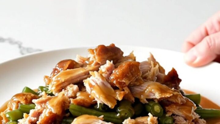 A white plate filled with cooked ground turkey and green beans glazed in a shiny honey garlic sauce.