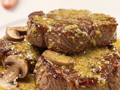 Slow cooker round steak Diane with mushrooms and a rich, creamy Dijon sauce served on a plate.