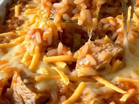 A top-down view of an unstuffed chicken cabbage roll casserole in a white dish, featuring layers of cabbage, rice