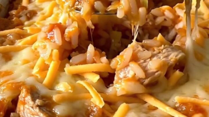 A top-down view of an unstuffed chicken cabbage roll casserole in a white dish, featuring layers of cabbage, rice