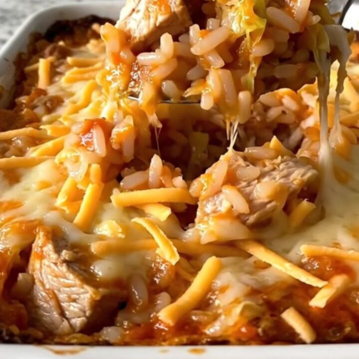 A top-down view of an unstuffed chicken cabbage roll casserole in a white dish, featuring layers of cabbage, rice