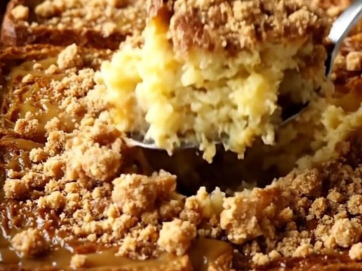 A warm, golden gingerbread French toast bake in a white ceramic dish on a beige counter.