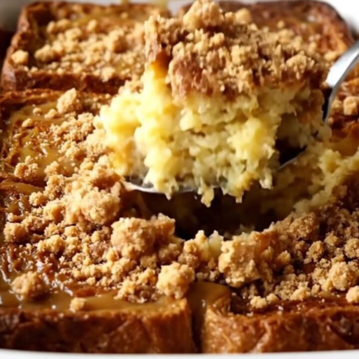A warm, golden gingerbread French toast bake in a white ceramic dish on a beige counter.