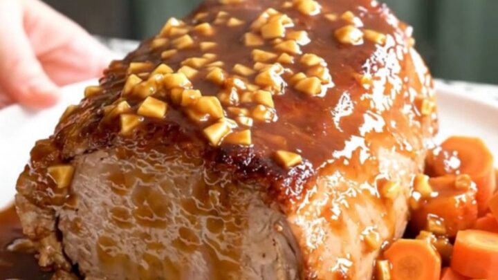 A slow cooker pork loin roast with carrots, glazed in a brown sugar garlic sauce.