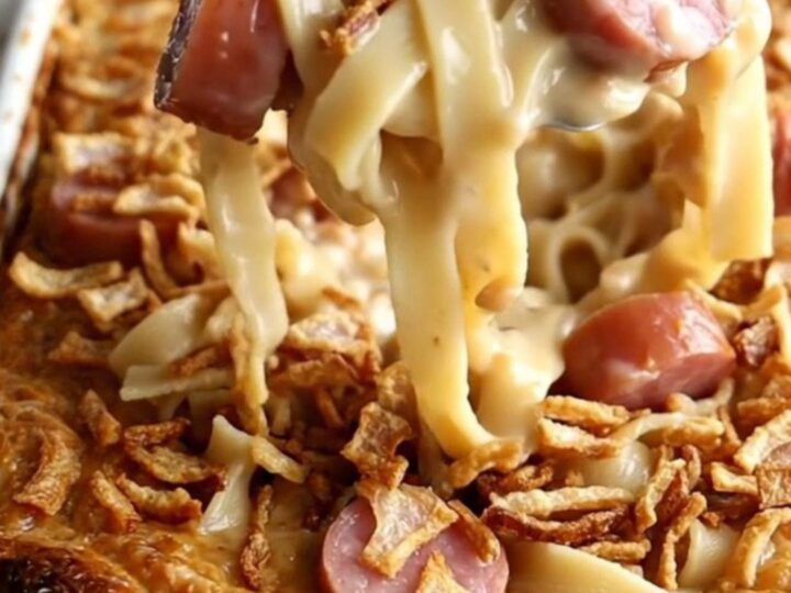 A top-down view of a rectangular baking dish filled with kielbasa and egg noodles before being baked.