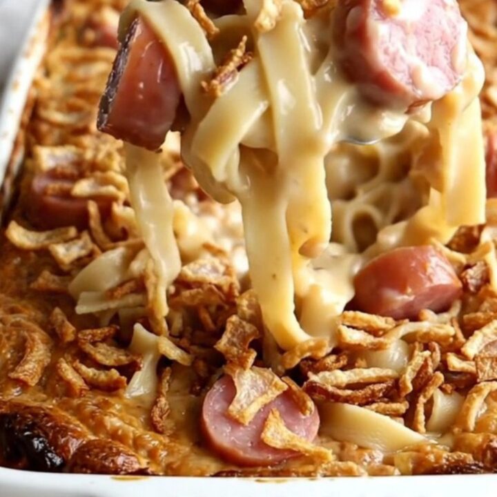 A top-down view of a rectangular baking dish filled with kielbasa and egg noodles before being baked.