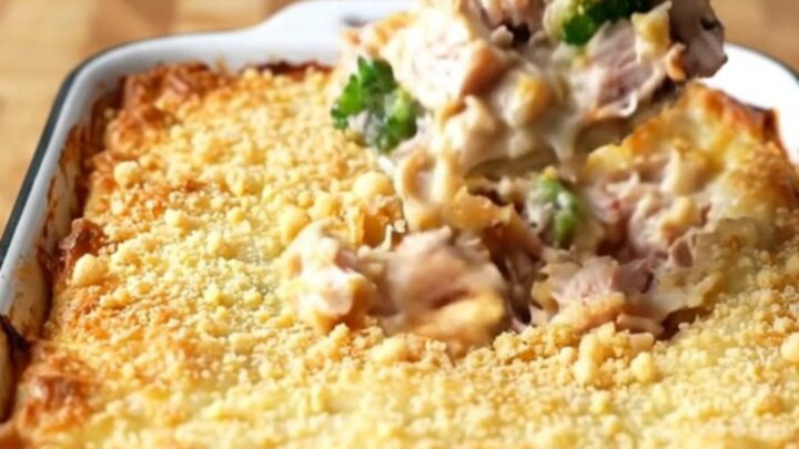 A top-down view of a rectangular baker filled with turkey chunks and broccoli coated in a creamy cheese sauce.