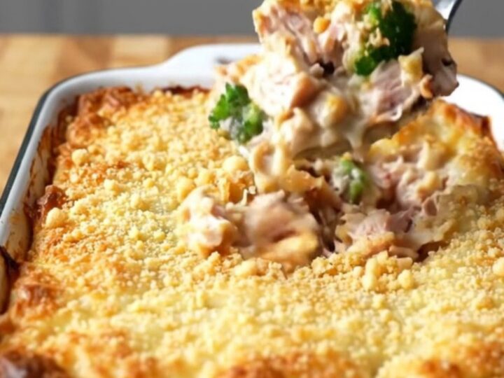 A top-down view of a rectangular baker filled with turkey chunks and broccoli coated in a creamy cheese sauce.