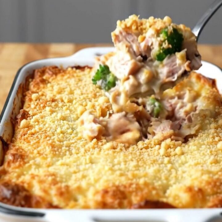 A top-down view of a rectangular baker filled with turkey chunks and broccoli coated in a creamy cheese sauce.