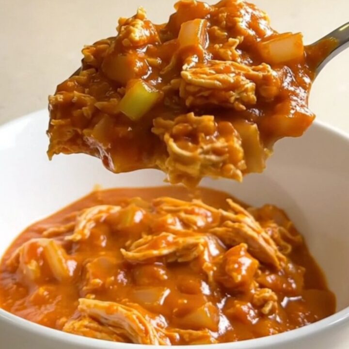 A white shallow bowl filled with Slow Cooker Buffalo Turkey Sloppy Joes, showing turkey, celery