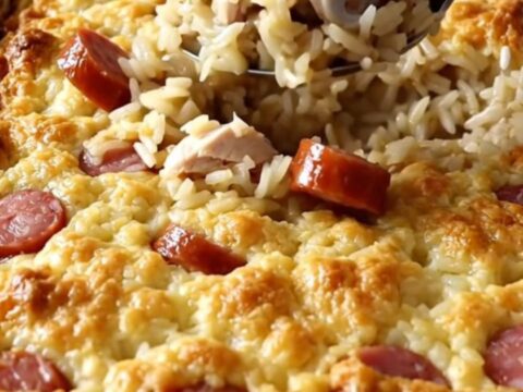 A large white ceramic baking dish filled with a golden, savory chicken and rice bake on a white quartz countertop.
