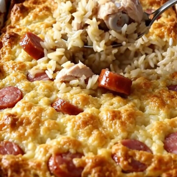 A large white ceramic baking dish filled with a golden, savory chicken and rice bake on a white quartz countertop.