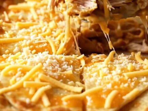 A golden-brown chicken quesadilla bake in a white ceramic dish.