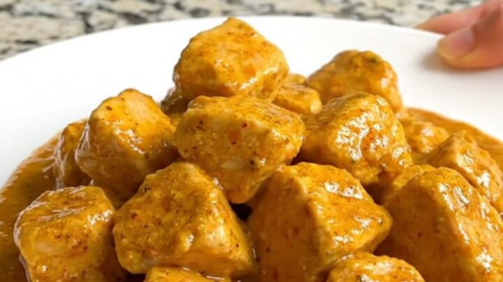 A bowl of creamy Crockpot Curry Chicken and Cauliflower served over rice.