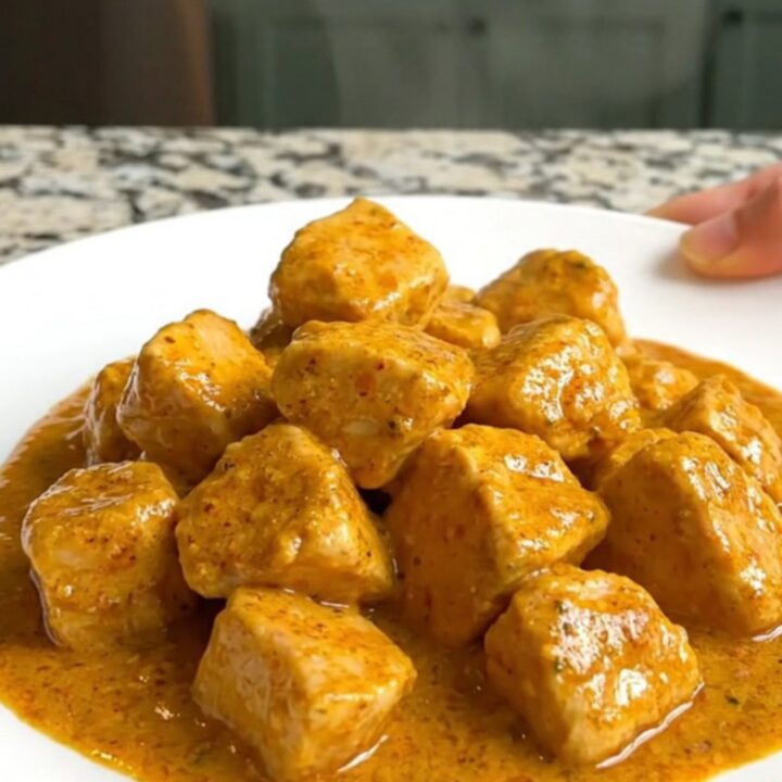 A bowl of creamy Crockpot Curry Chicken and Cauliflower served over rice.