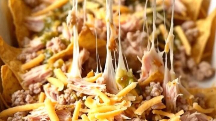 A large enameled rectangular baker filled with a layered nacho bake featuring ground turkey, salsa verde