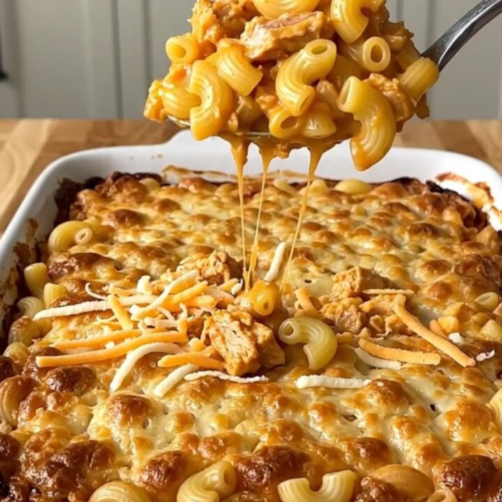 A top-down view of a rectangular ceramic dish filled with buffalo turkey mac and cheese before baking.