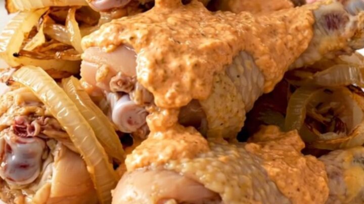 Slow cooker chicken drumsticks coated in a creamy, pink-orange comeback sauce on a white plate.