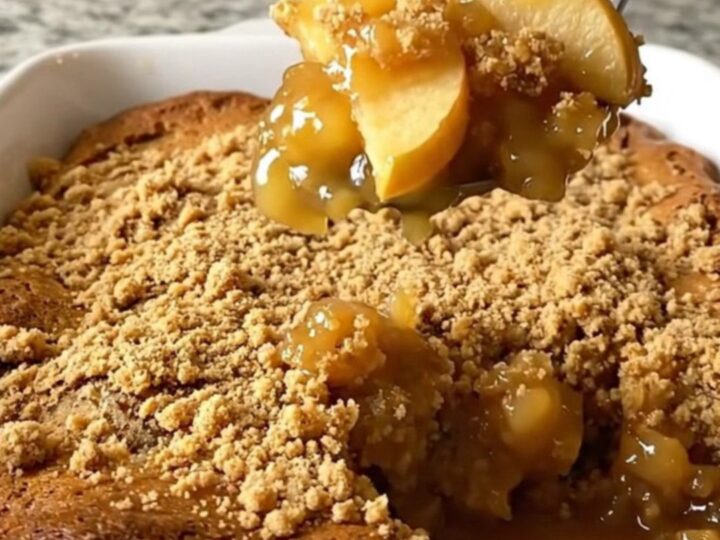 A top-down view of a rectangular baking dish filled with apple gingerbread dump cake on a granite countertop.