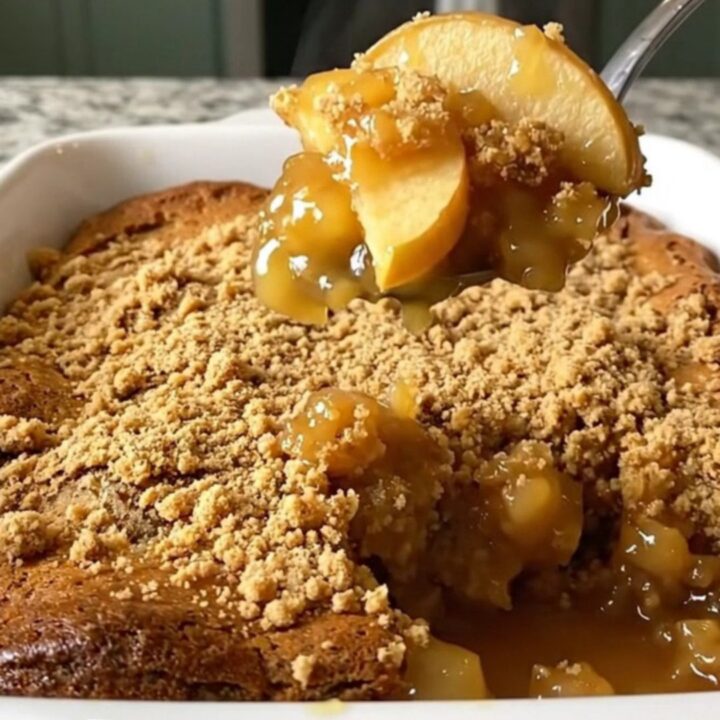 A top-down view of a rectangular baking dish filled with apple gingerbread dump cake on a granite countertop.