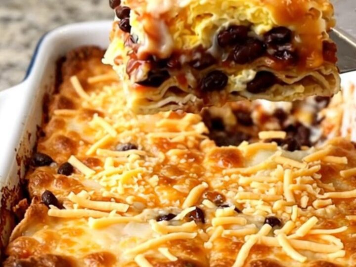 A top-down view of a golden, baked Huevos Rancheros casserole in a rectangular white dish.