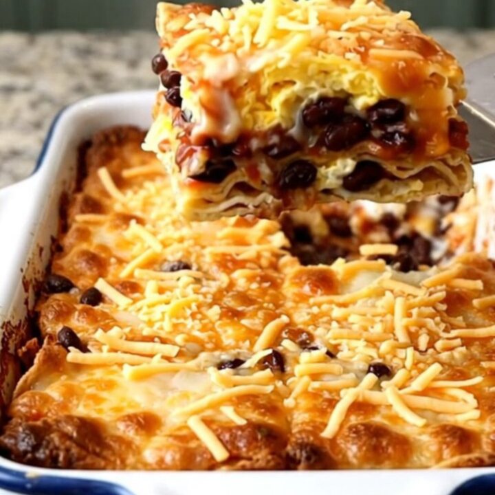 A top-down view of a golden, baked Huevos Rancheros casserole in a rectangular white dish.