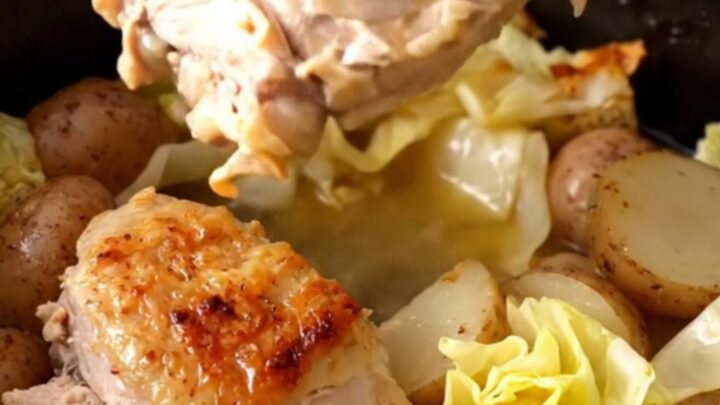 A slow cooker filled with cooked turkey tenderloins, cabbage wedges, and halved baby potatoes in a savory broth.