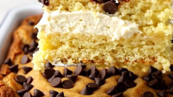 A top-down view of a golden-brown Chocolate Chip Gooey Butter Cake in a white rectangular baking dish.